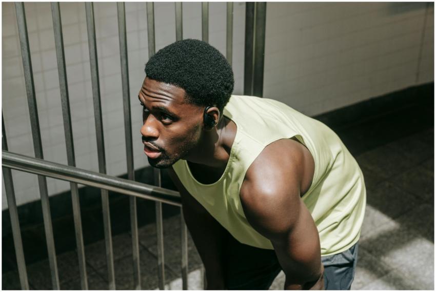 A muscular man in sportswear takes a break, showca