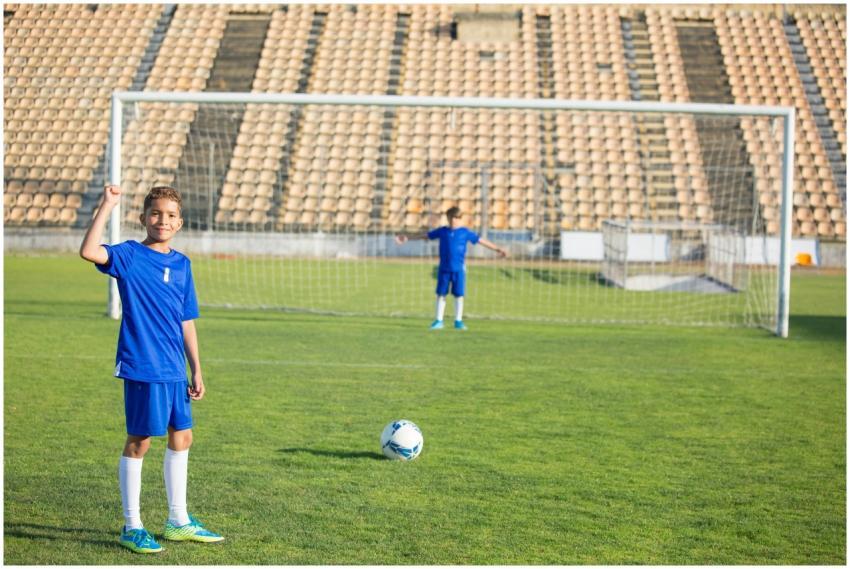 Two young boys playing soccer on a grassy field un