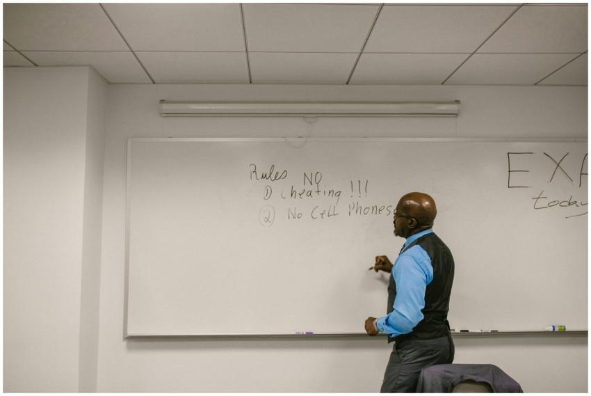 Instructor writing exam rules on a whiteboard in a