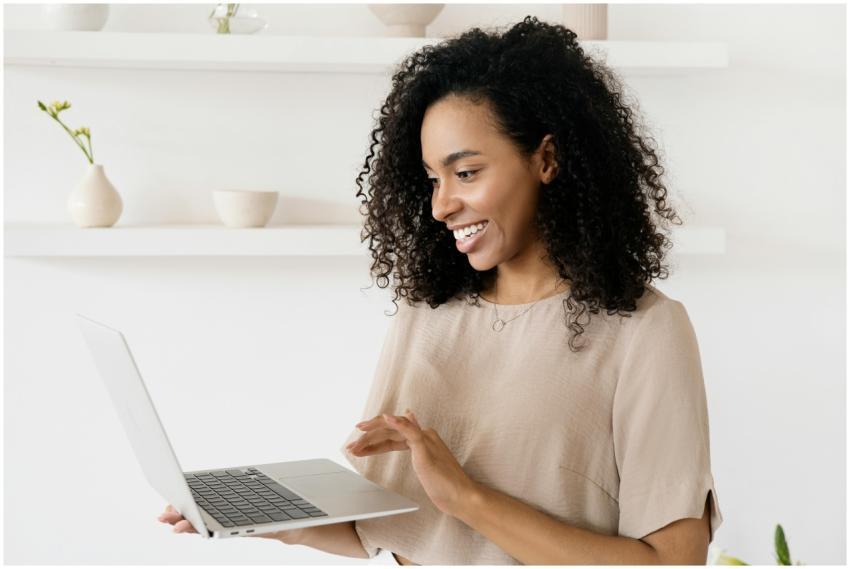 Smiling woman working on a laptop in a modern home