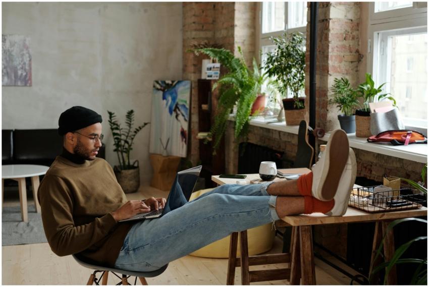 Young stylish man working on a laptop in a cozy ur