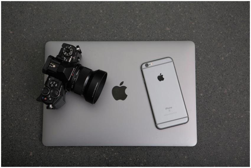 High-angle shot of DSLR camera, MacBook, and iPhon