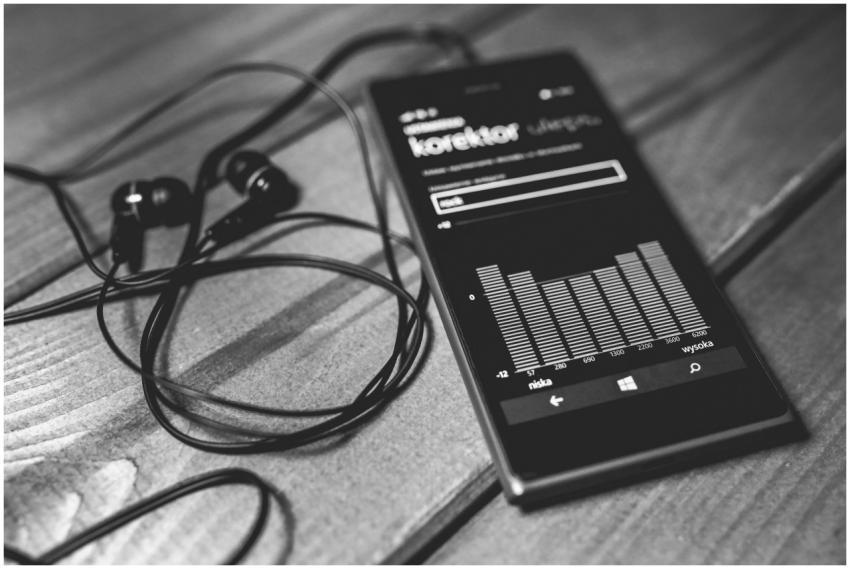 Monochrome photo of a smartphone with earphones an