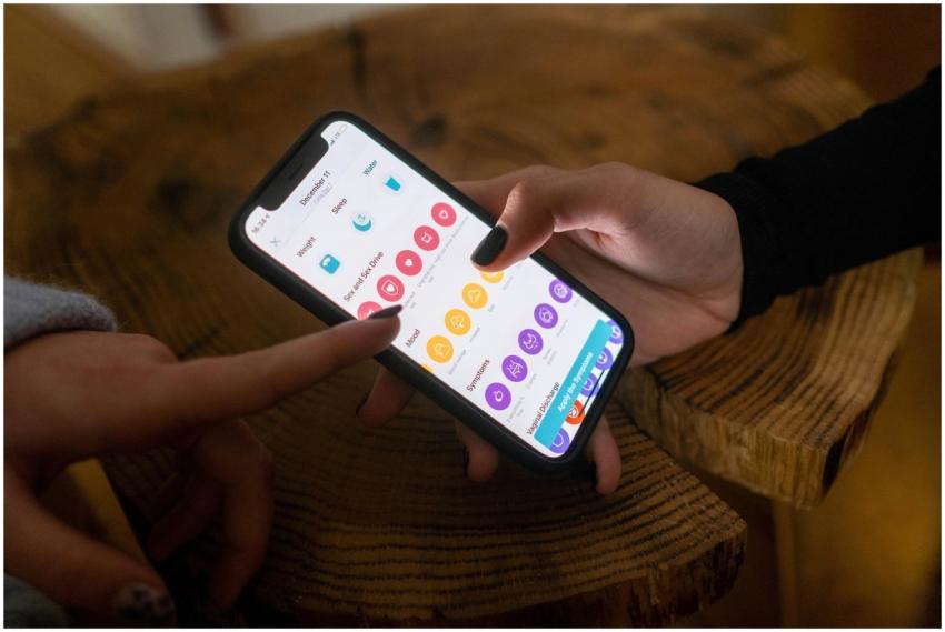 Close-up of hands using a fertility tracking app o