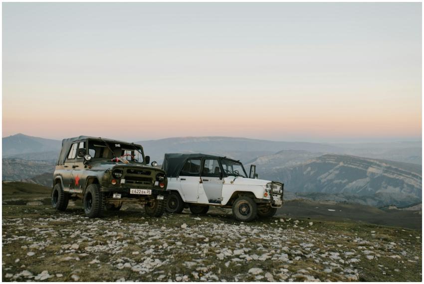 Two vintage off-road vehicles parked on a rocky hi