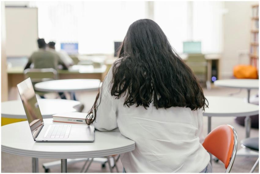 A student focused on studying at a library table w