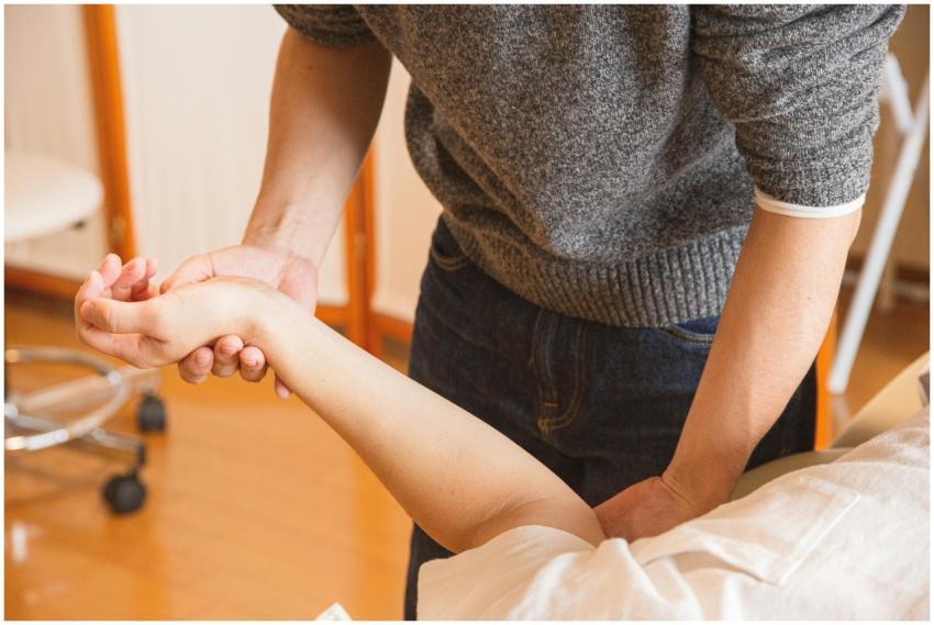 Therapist assisting a patient with wrist therapy.