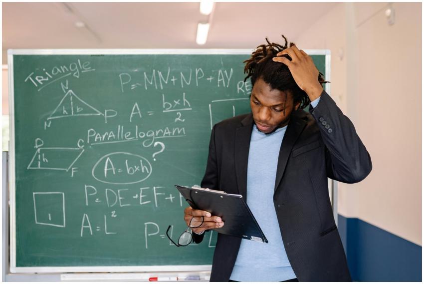 A teacher in a classroom solving math problems on