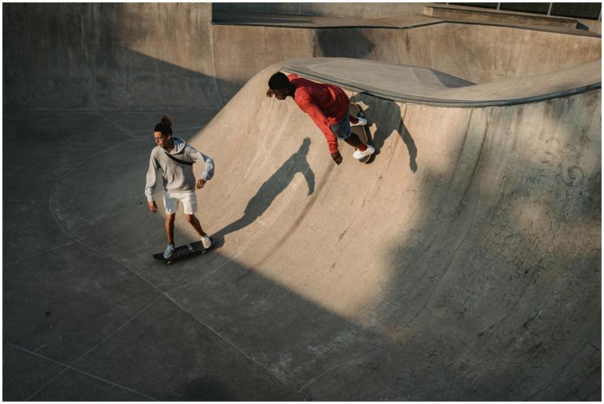 Two skateboarders performing tricks in an urban sk