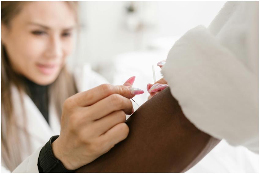 Close-up of a therapist performing acupuncture on