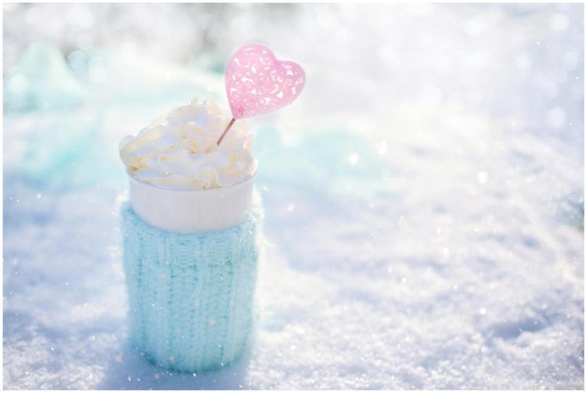 Warm beverage topped with cream in snow, perfect f