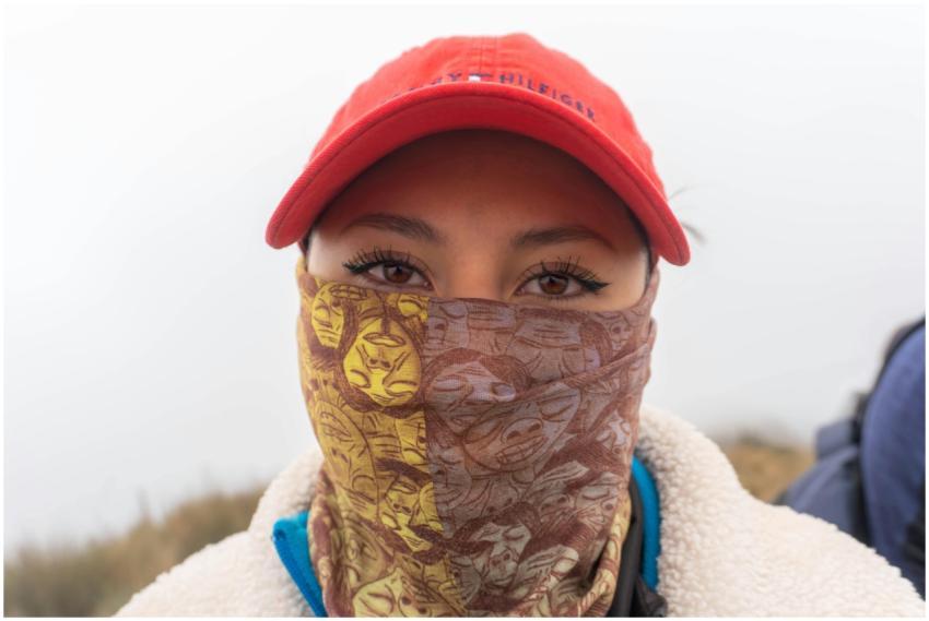 Close-up of a woman with a red hat and patterned f