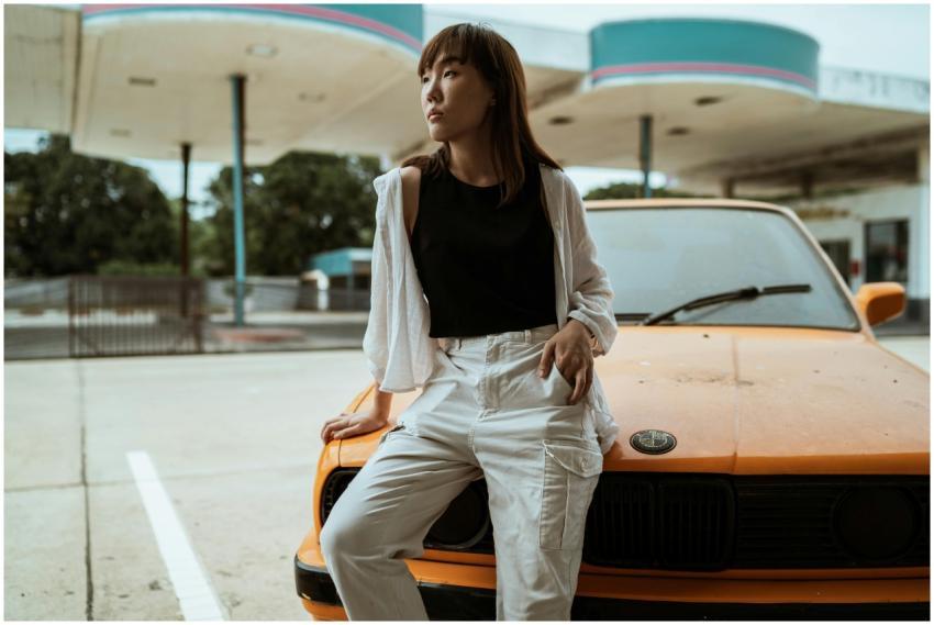 Slim pensive Asian woman in casual wear sitting wi