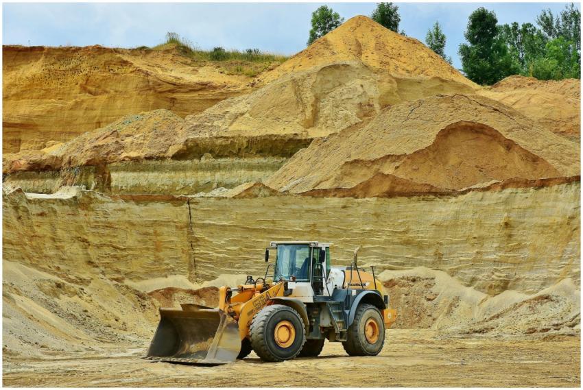 An excavator working in an open pit mine surrounde