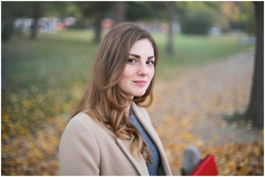 A woman smiles in an autumn setting in Budapest, H