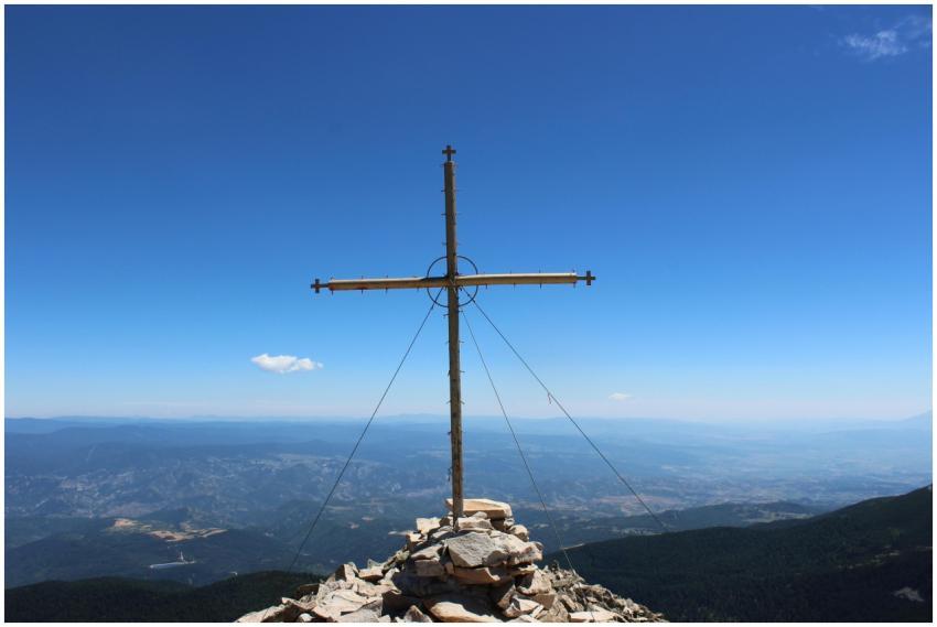 Stunning view of a cross on a mountain peak overlo