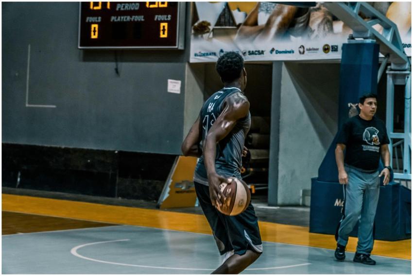 Basketball player performing on an indoor court wi