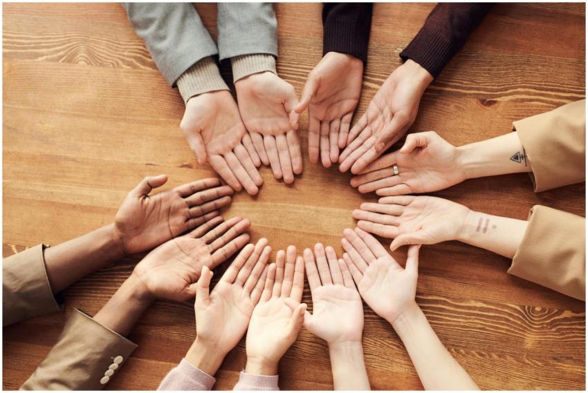 Top view of diverse hands forming a circle on a wo