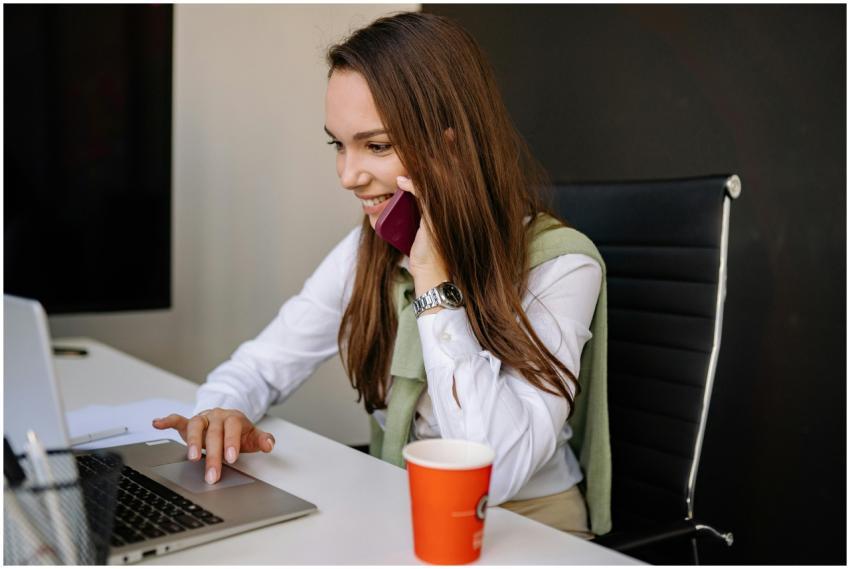 Smiling businesswoman multitasking with a smartpho