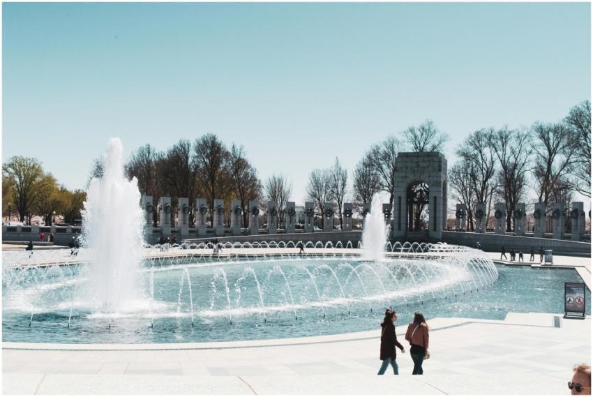Picturesque fountain with people walking in a hist