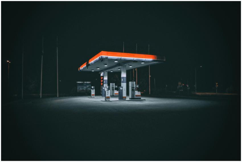 An isolated and illuminated gas station at night,