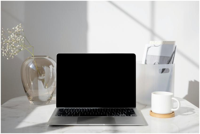 A clean and modern desk with a laptop, coffee cup,