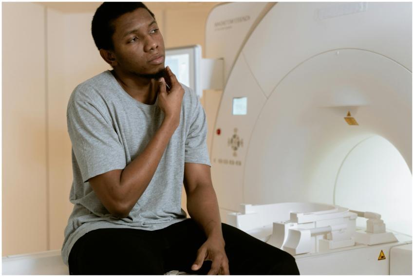 A man sits nervously in an MRI scan room, contempl