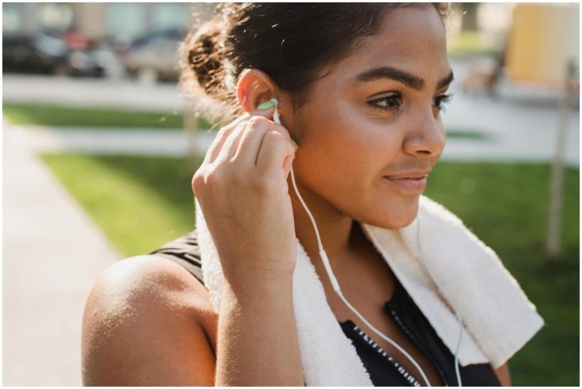Young woman smiling and wearing earphones, prepari