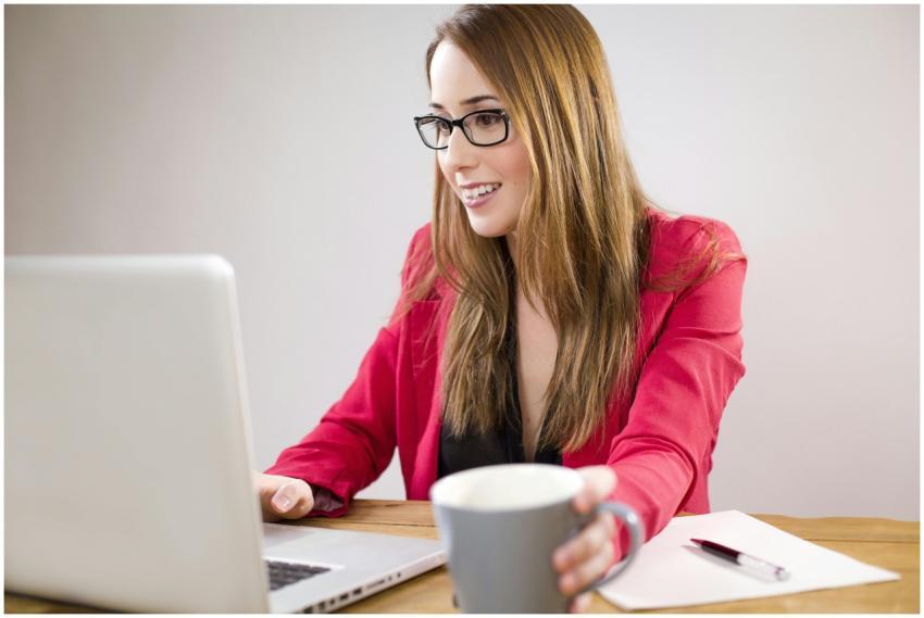 A smiling young businesswoman in a red jacket work