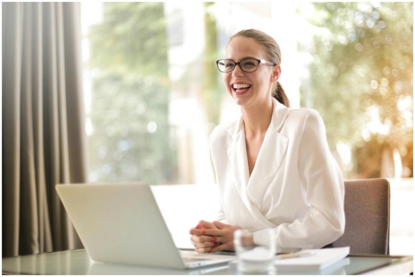 Cheerful businesswoman in glasses working on a lap