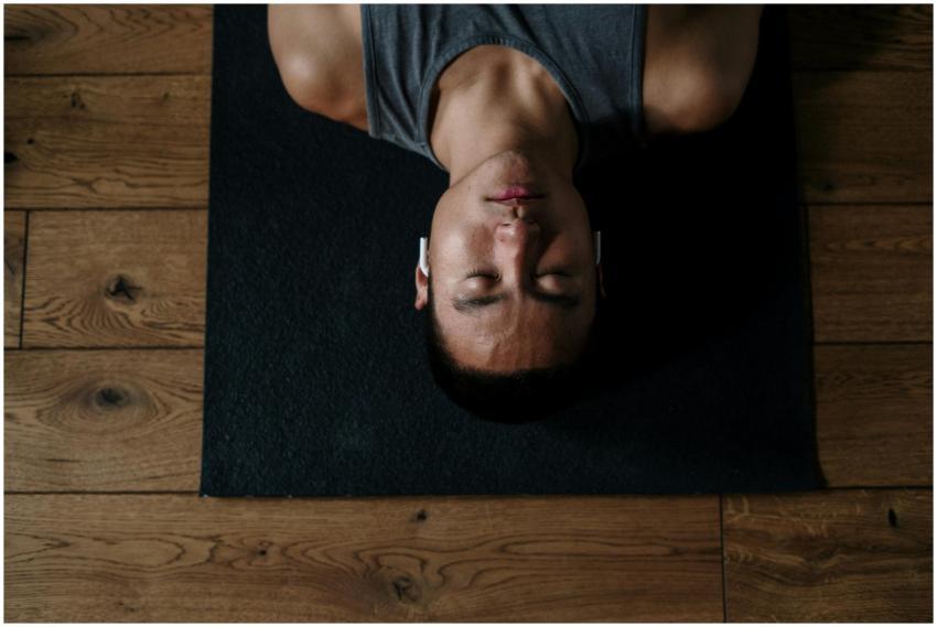 Young man meditating indoors on a yoga mat with he