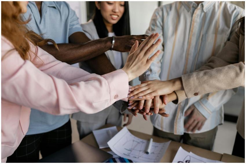 Diverse team members putting hands together in an