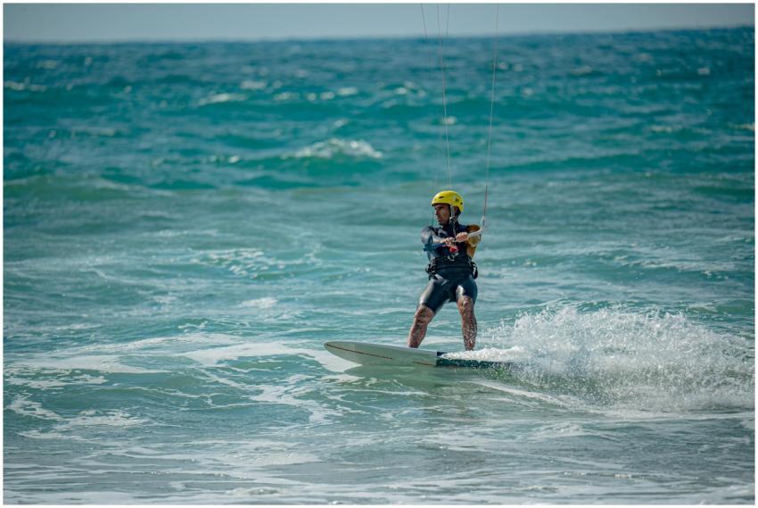 A kiteboarder skillfully navigates the waves on a