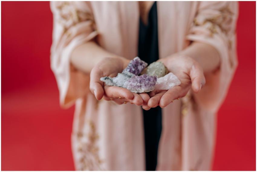 Elegant hands holding healing crystals against a v