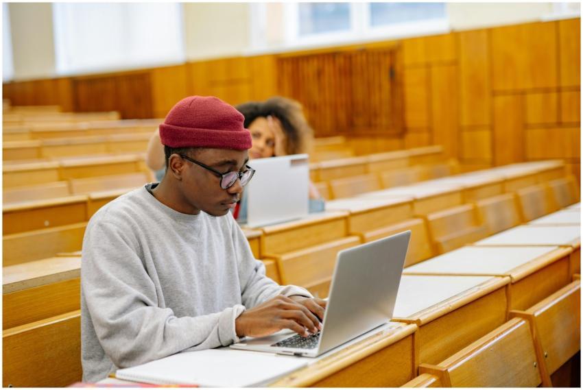 Students focus on laptops in a spacious university