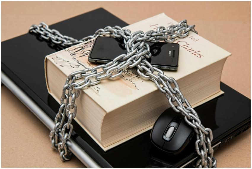 Chain-locked book, phone, and laptop symbolizing d