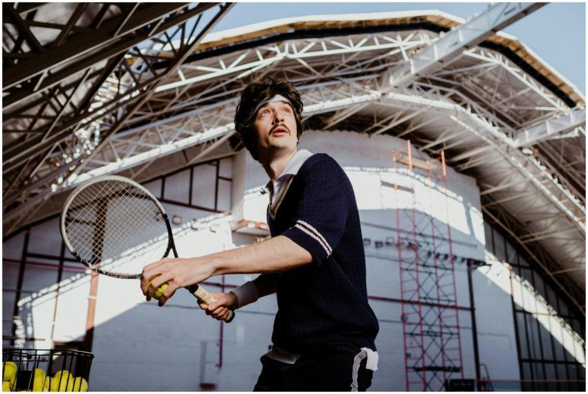 Tennis player in action on an indoor court, holdin