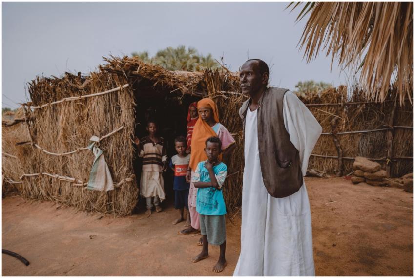 Portrait of family standing outside a traditional