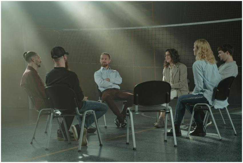 A group therapy session with six adults seated in