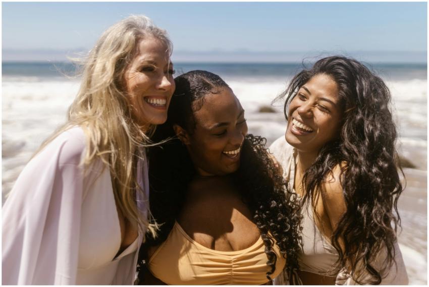 Three women enjoying a sunny day at the beach, lau