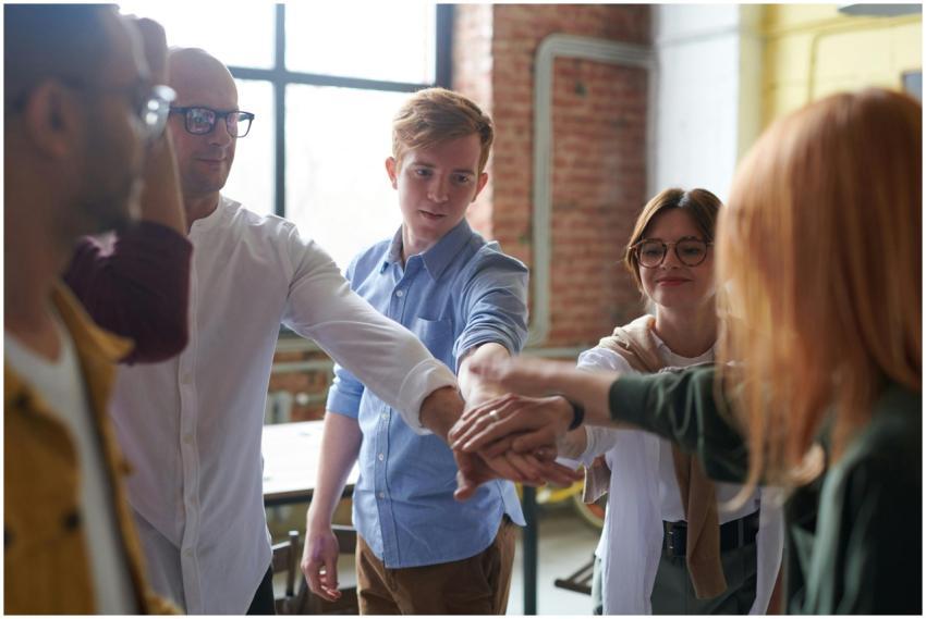 A diverse group of young adults joins hands, symbo