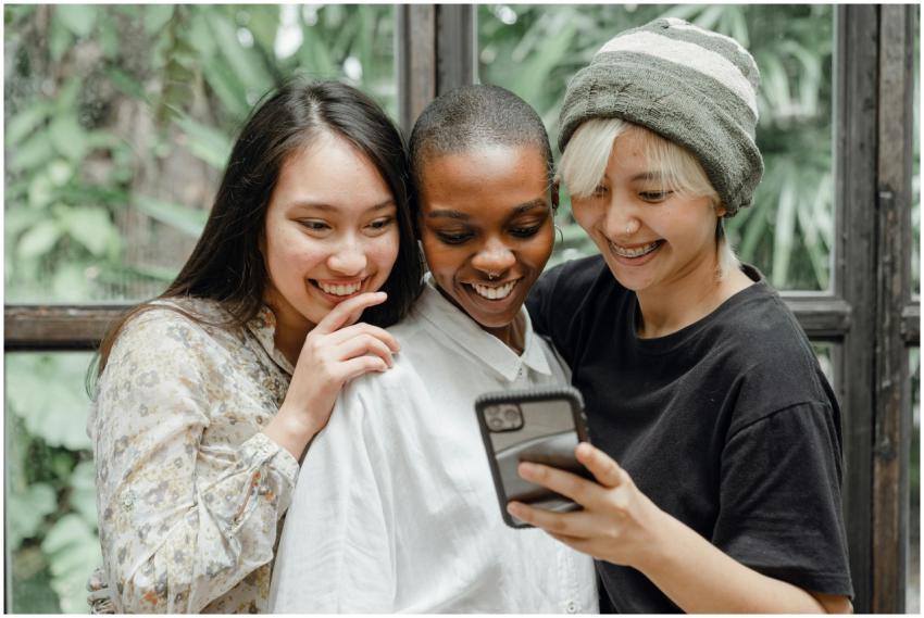 Three diverse friends happily take a selfie indoor