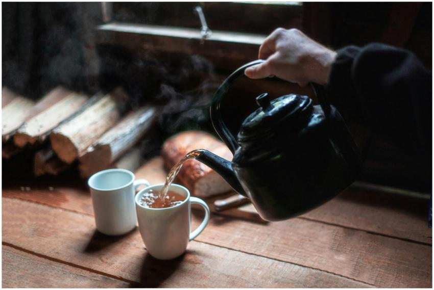 Rustic scene of hot tea being poured from a teapot