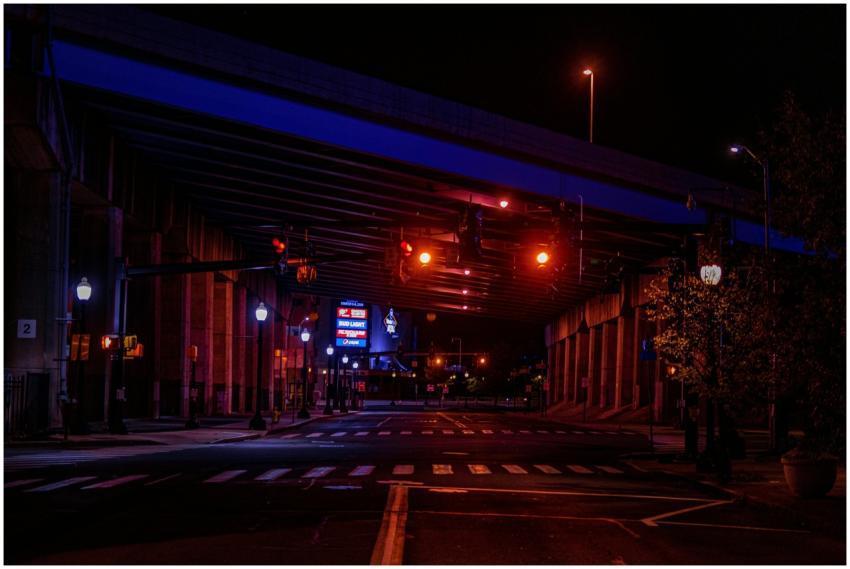 Moody nighttime urban scene featuring a lit bridge
