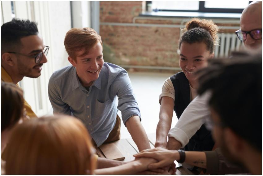 A diverse group of young professionals joining han