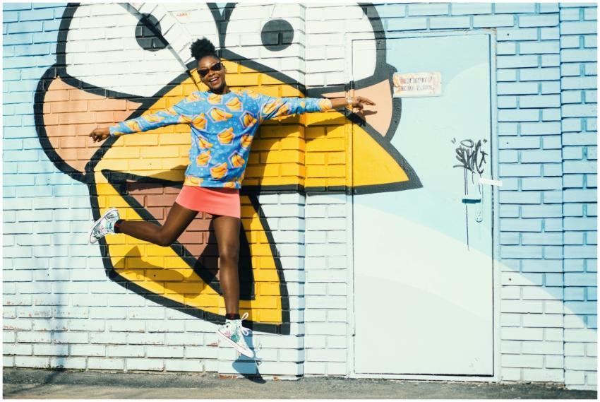 A young woman jumps happily in front of a vibrant