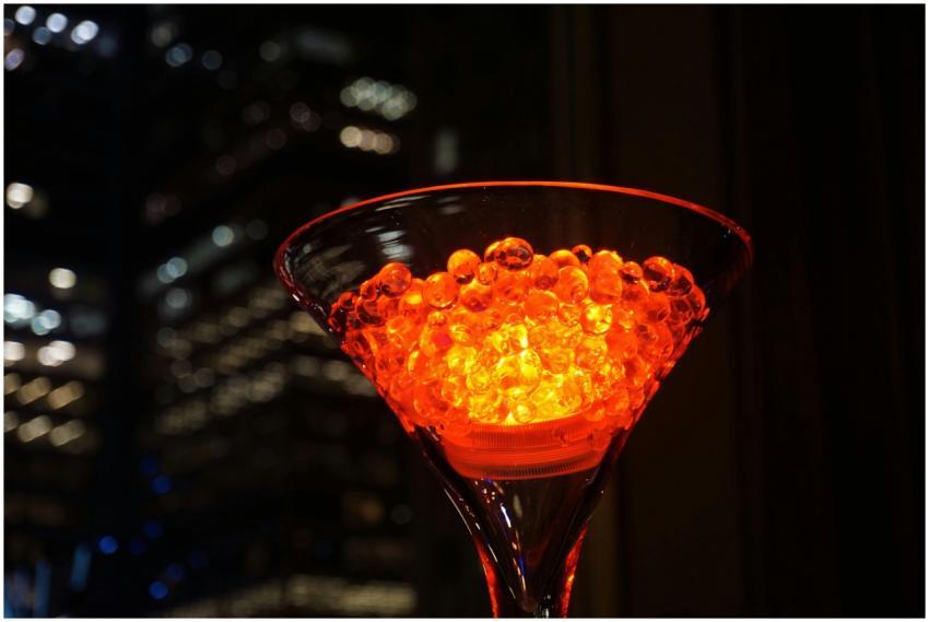 Vibrant illuminated cocktail glass with glowing be