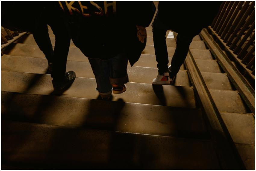 A group of people walking down a dimly lit stairca