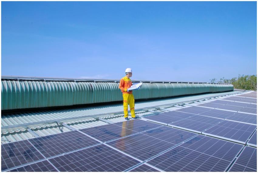 Technician examining solar panels on a rooftop, em