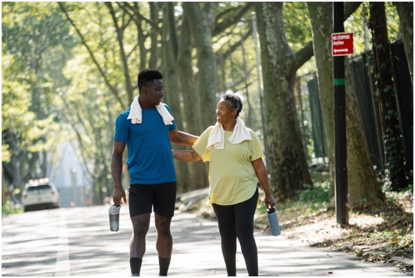 Two people jogging in a sunlit park, promoting fit